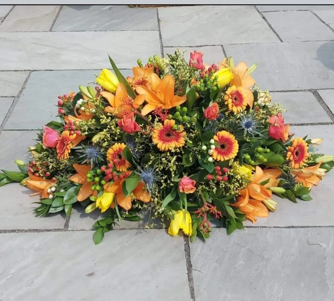 Orange and yellow coffin spray, handmade by Polly's Flowers in Tipton