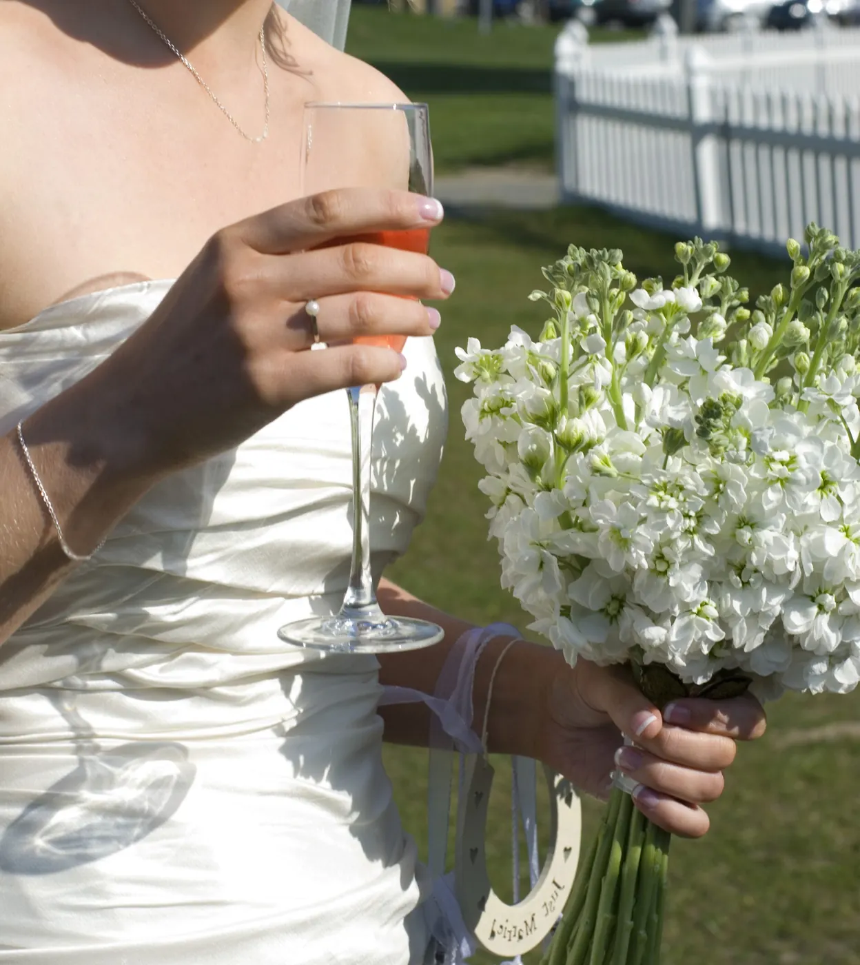 Bride holding a white hand-tied wedding bouquet by Polly's Flowers